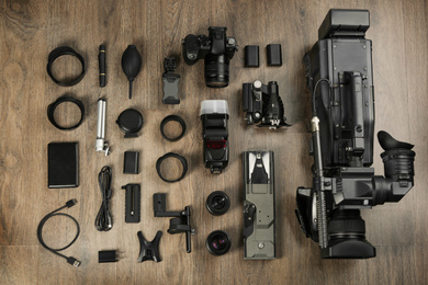 Photo of Flat lay composition with video camera and other equipment on wooden table
