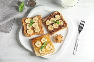 Photo of Tasty toasts with banana, mint and chia seeds served on table, top view