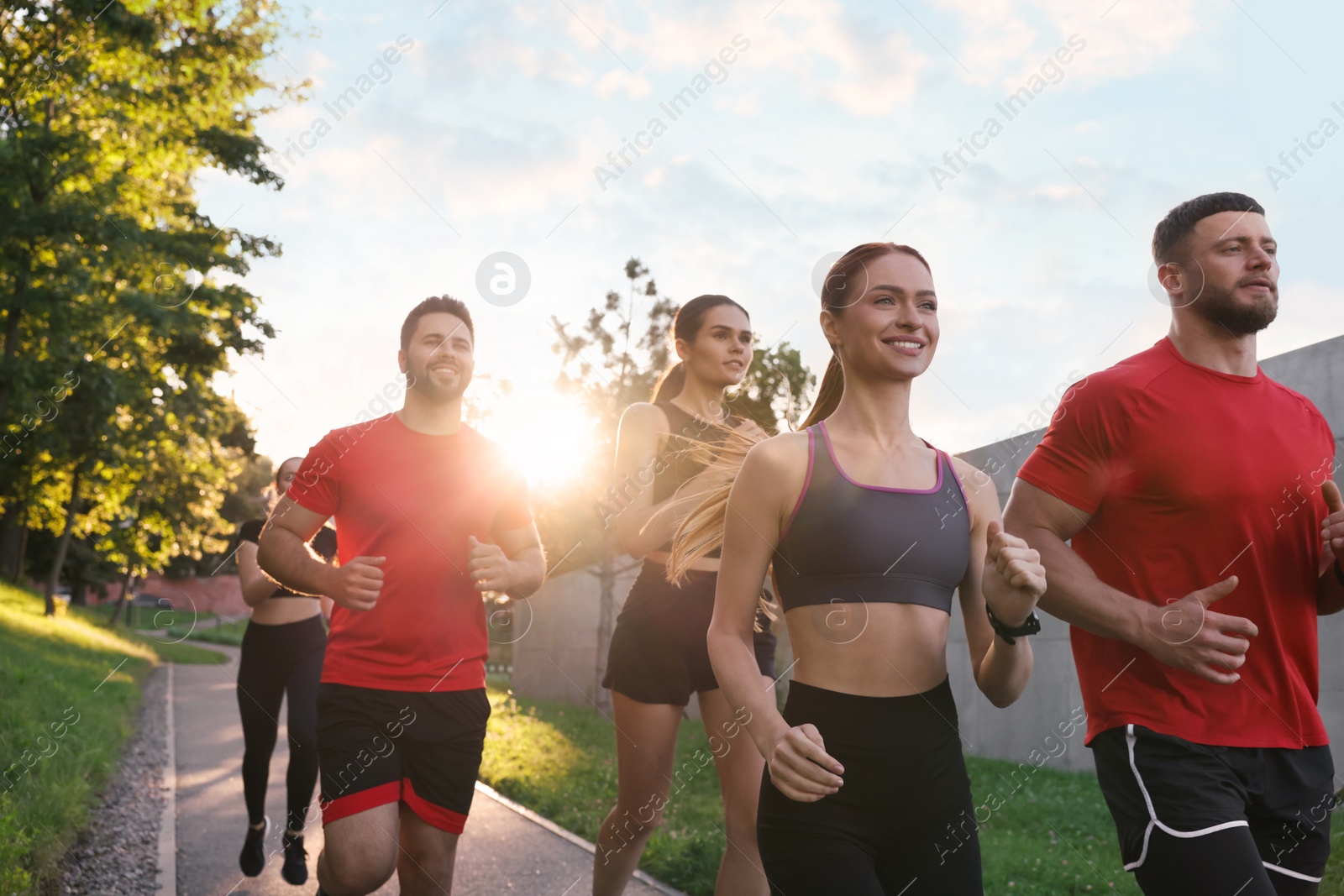 Photo of Group of people running outdoors on sunny day