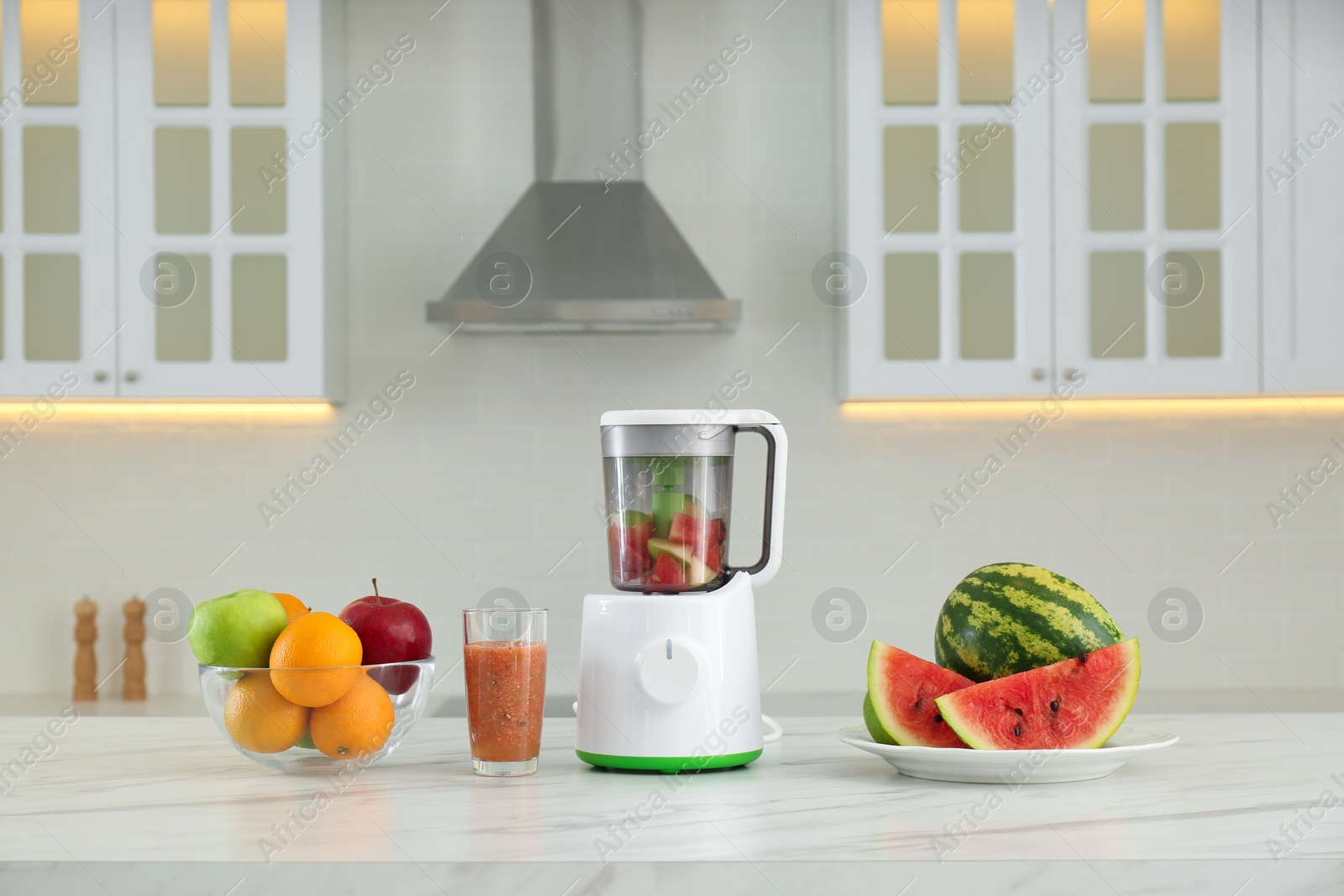 Photo of Blender and smoothie ingredients on table in kitchen