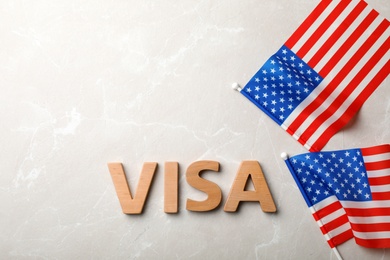 Photo of Flat lay composition with word VISA and flags of USA on gray background. Space for text