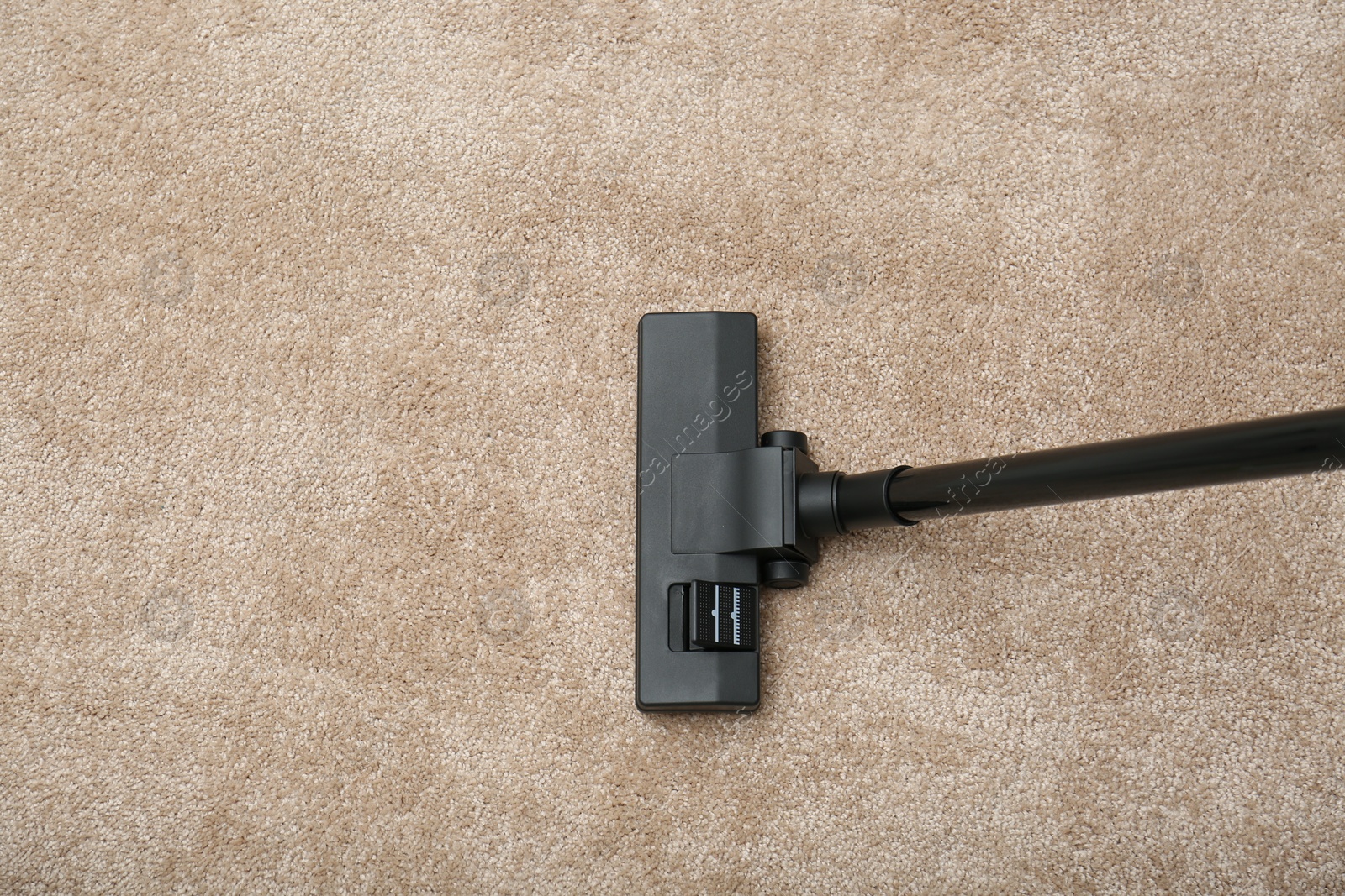 Photo of Removing dirt from carpet with modern vacuum cleaner indoors, top view