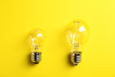 Photo of Vintage filament lamp bulbs on yellow background, top view