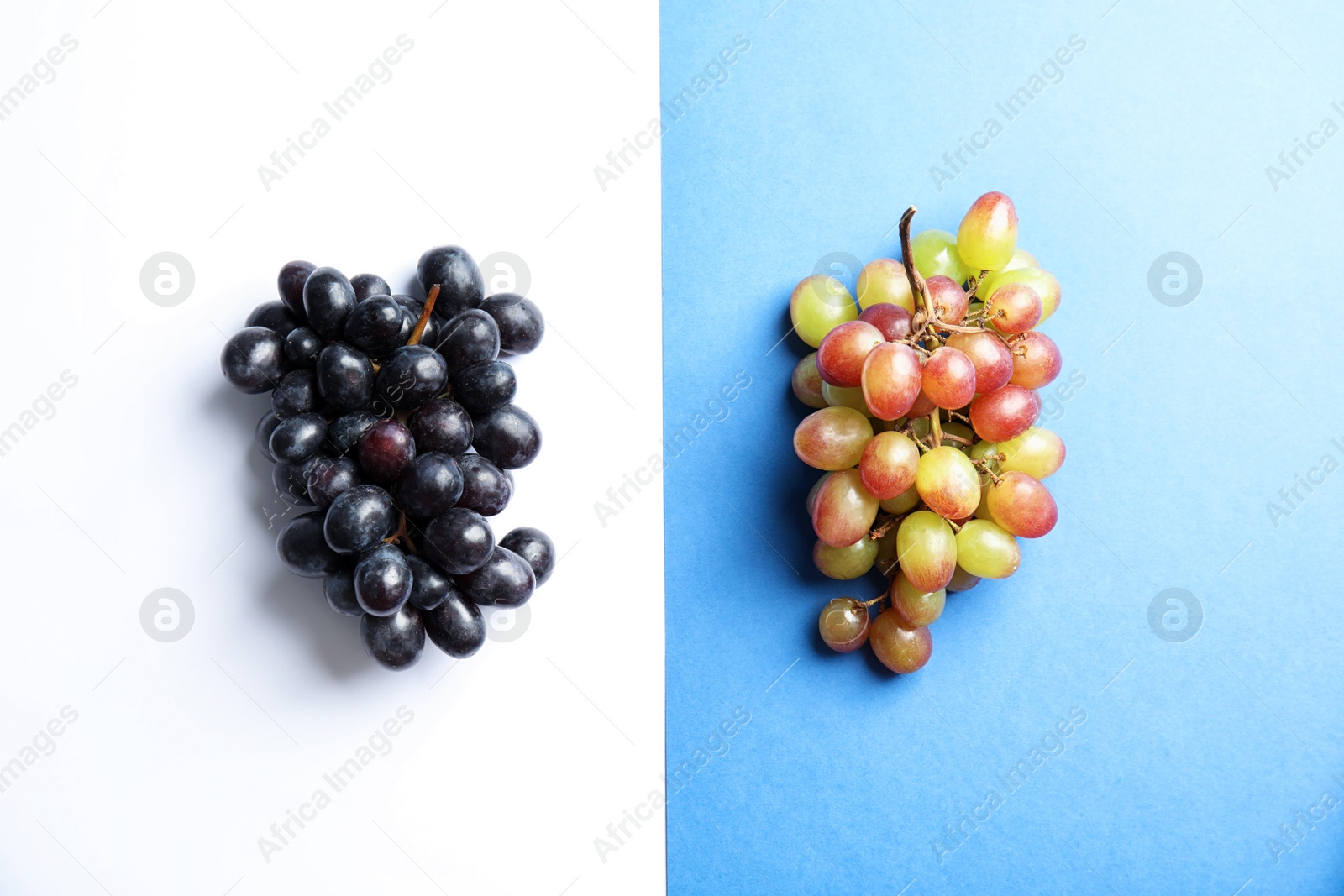 Photo of Different fresh ripe juicy grapes on color background, top view