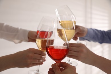 Photo of People clinking glasses of wine on white background, closeup