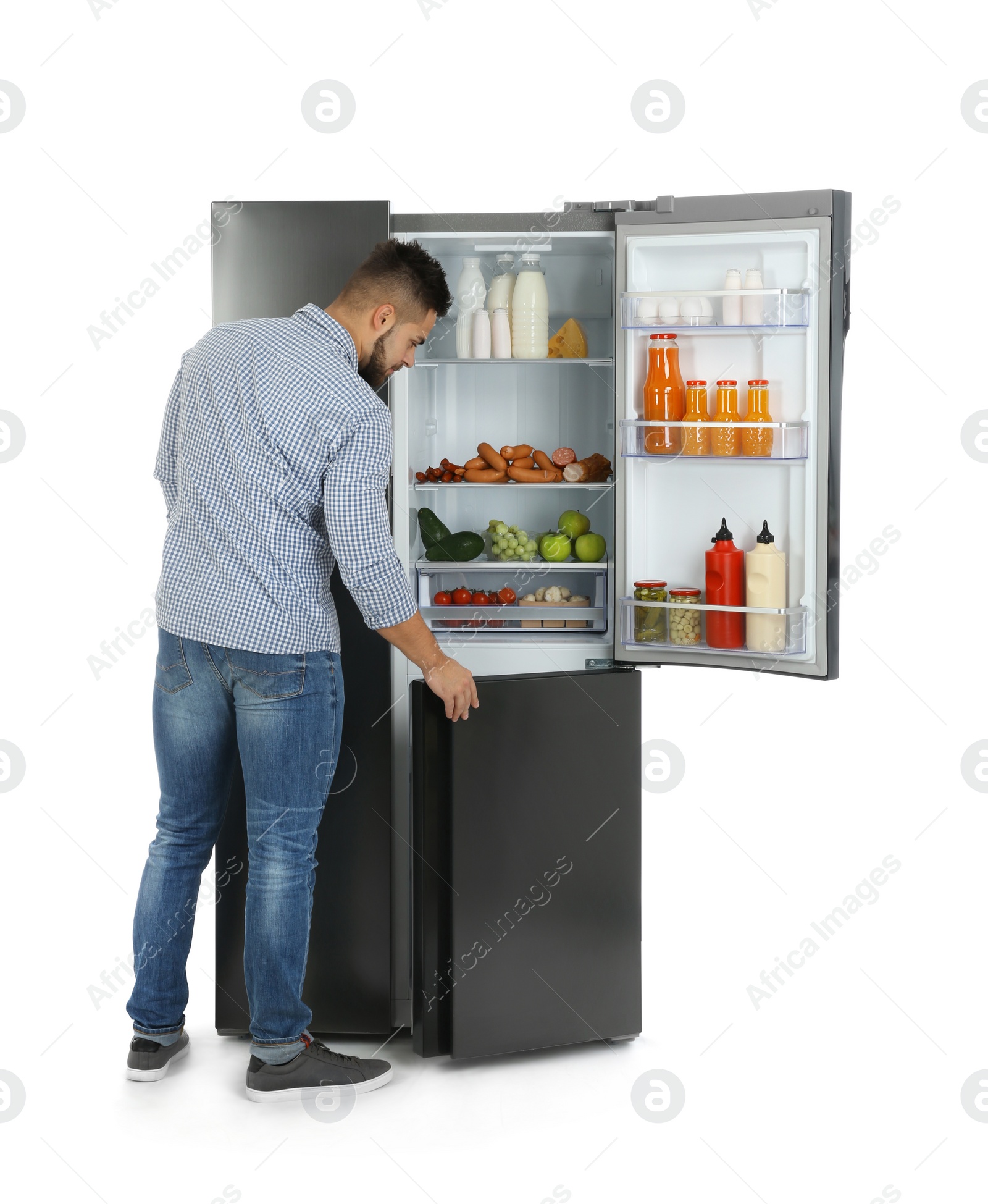 Photo of Young man opening refrigerator on white background