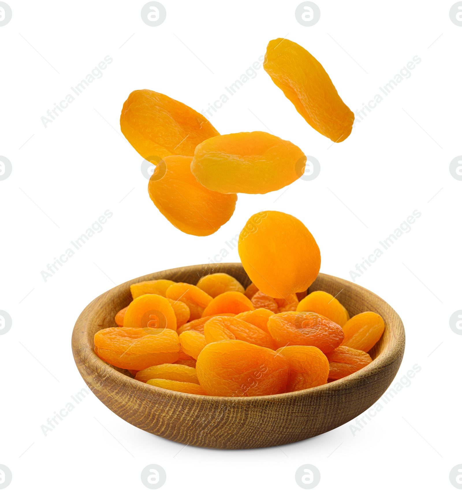 Image of Tasty dried apricots falling into bowl on white background