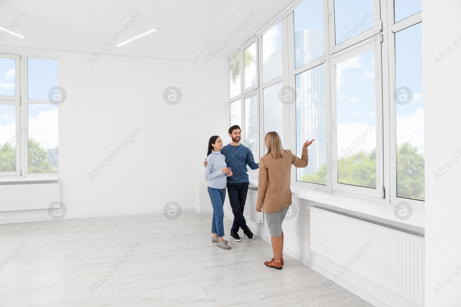 Photo of Real estate agent showing new apartment to couple