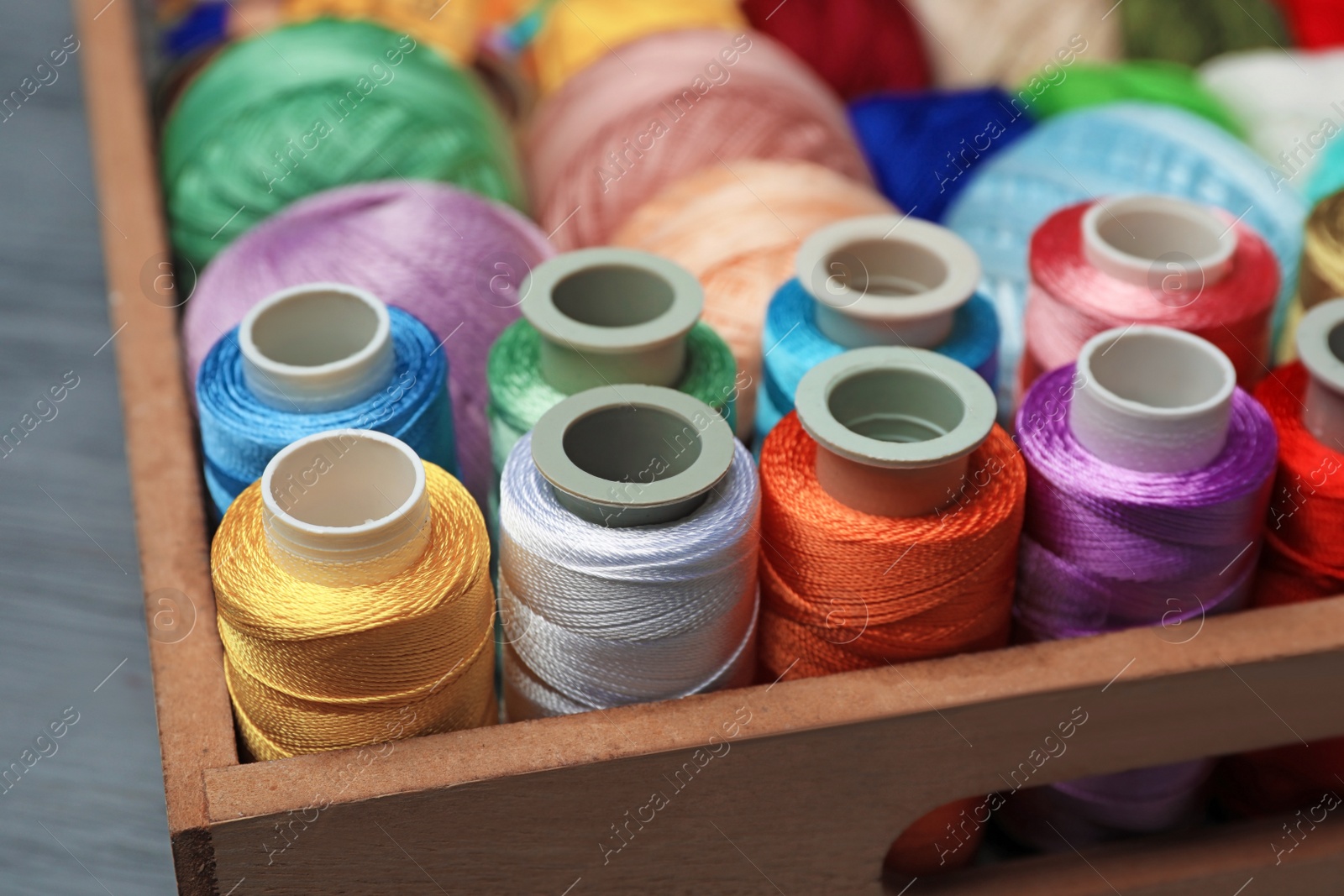 Photo of Drawer with color sewing threads, closeup
