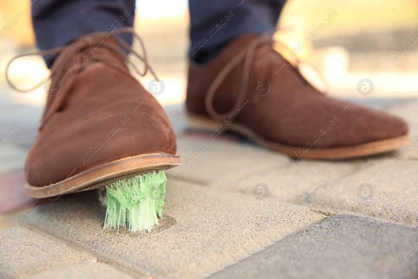 Photo of Man stepping in chewing gum on sidewalk. Concept of stickiness