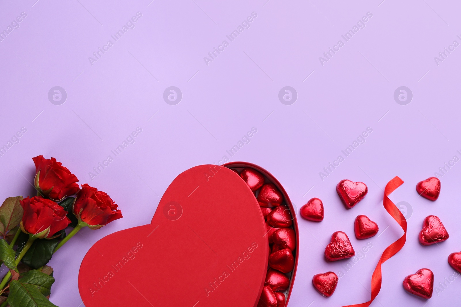 Photo of Heart shaped chocolate candies, ribbon and bouquet  on violet background, flat lay. Space for text