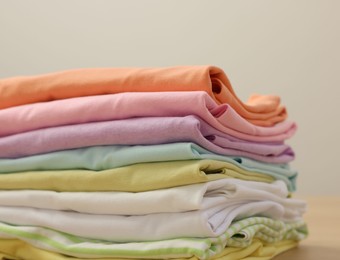 Photo of Stack of clean clothes on wooden table