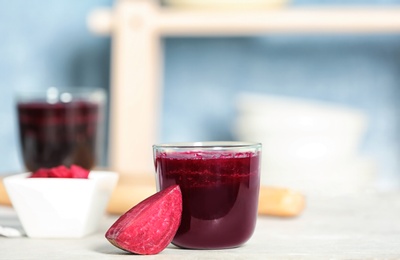 Glass of beet smoothie on table against blurred background