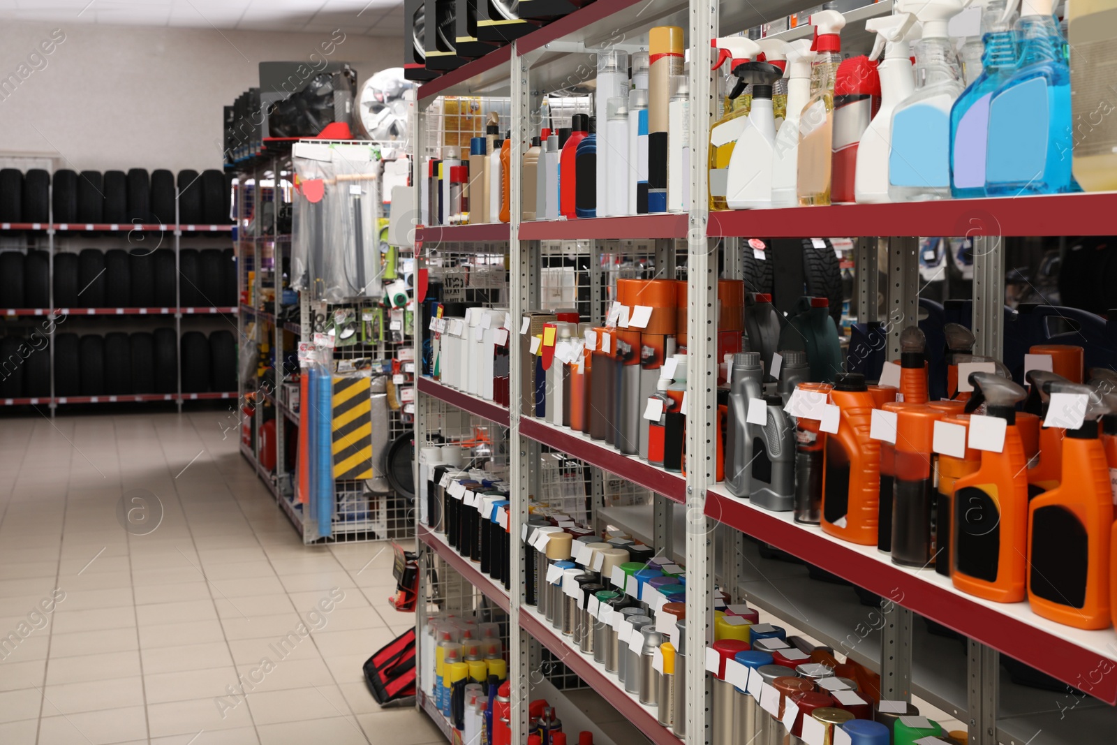 Image of Shelves with car care products and tires in auto store