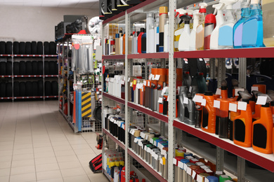 Shelves with car care products and tires in auto store