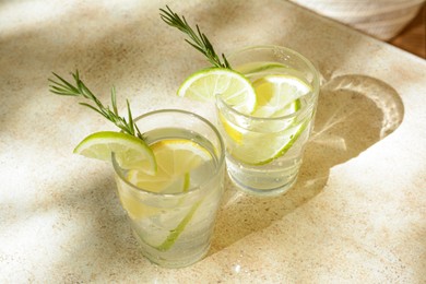 Glasses of tasty refreshing lemonade on light table. Summer drink