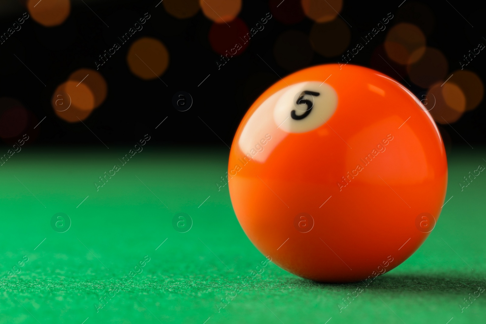 Photo of Billiard ball with number 5 on green table, closeup. Space for text