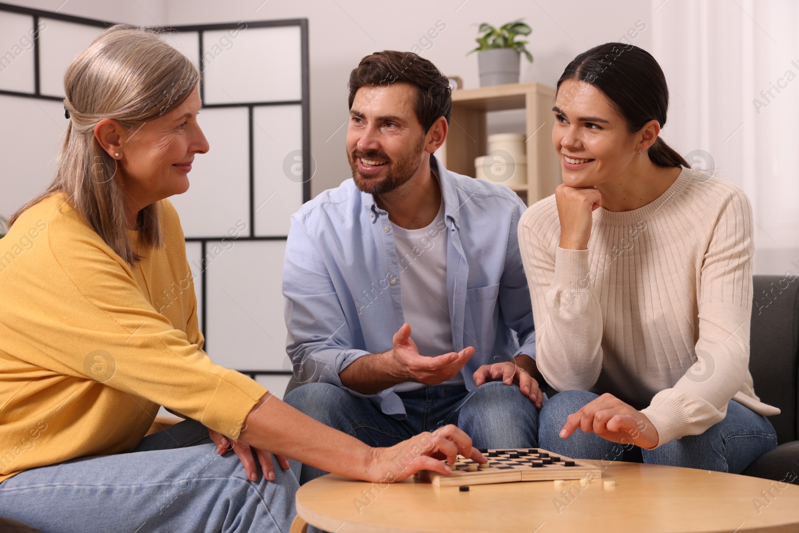 Photo of Family talking while playing checkers at home