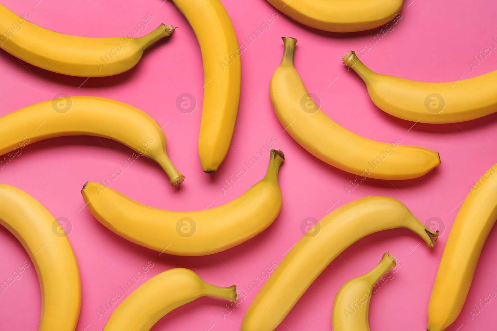 Photo of Ripe yellow bananas on pink background, flat lay