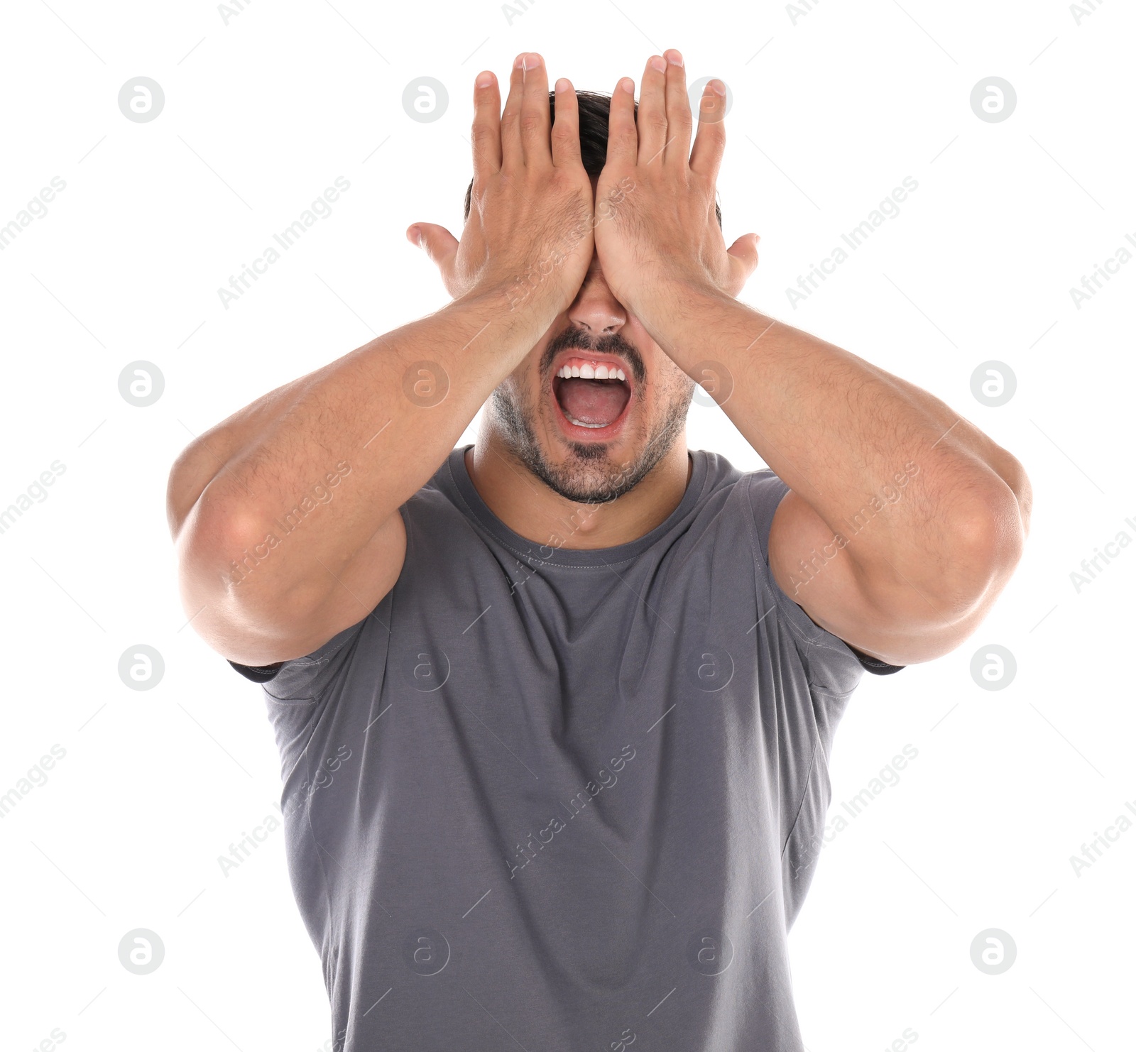 Photo of Young man being blinded and covering eyes with hands on white background