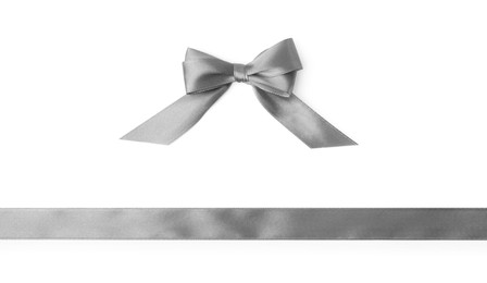 Grey satin ribbon and bow on white background, top view
