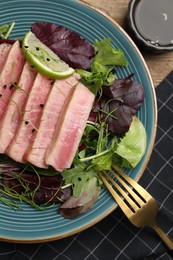 Photo of Pieces of delicious tuna steak with salad served on table, flat lay