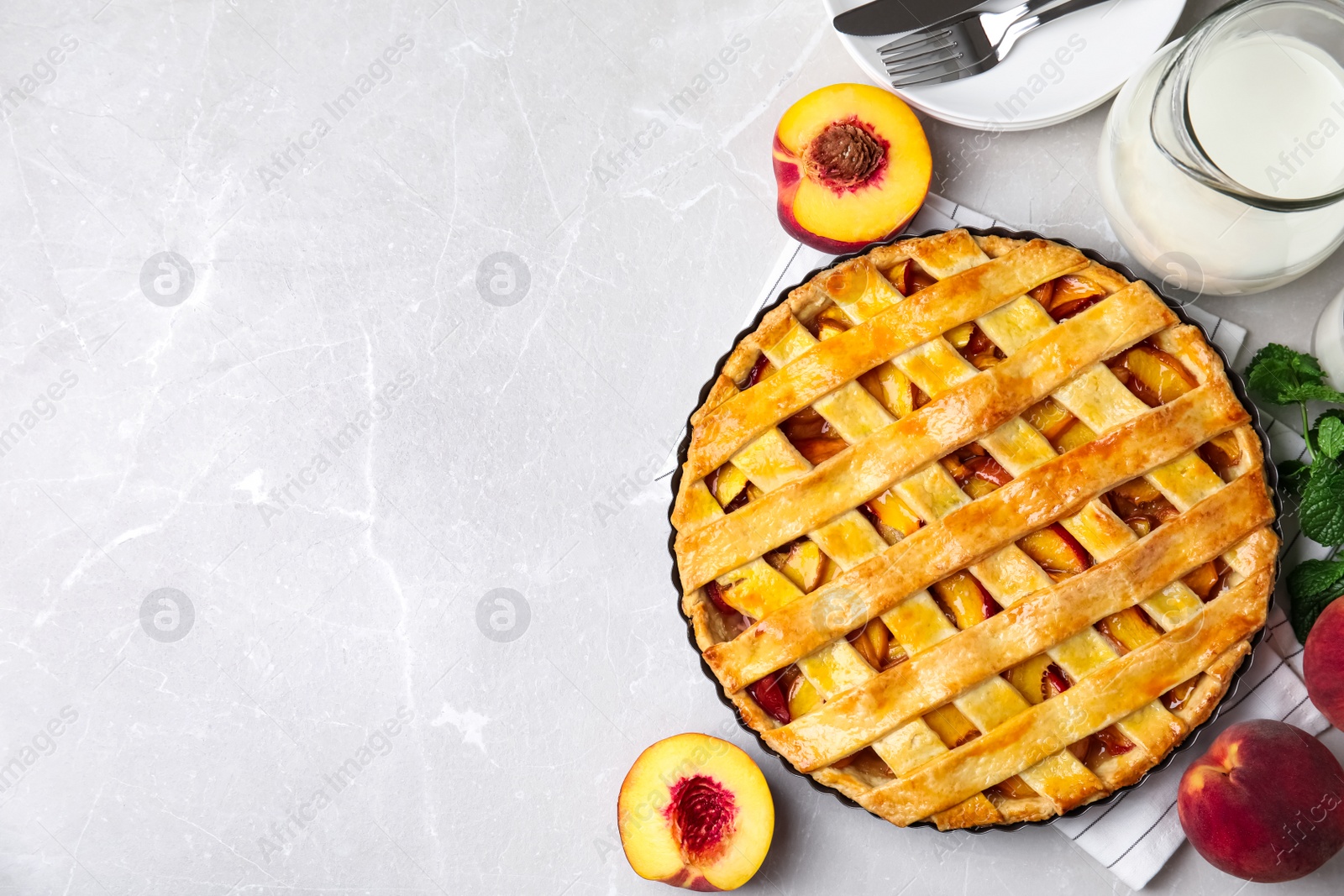 Photo of Delicious fresh peach pie served on light grey table, flat lay. Space for text