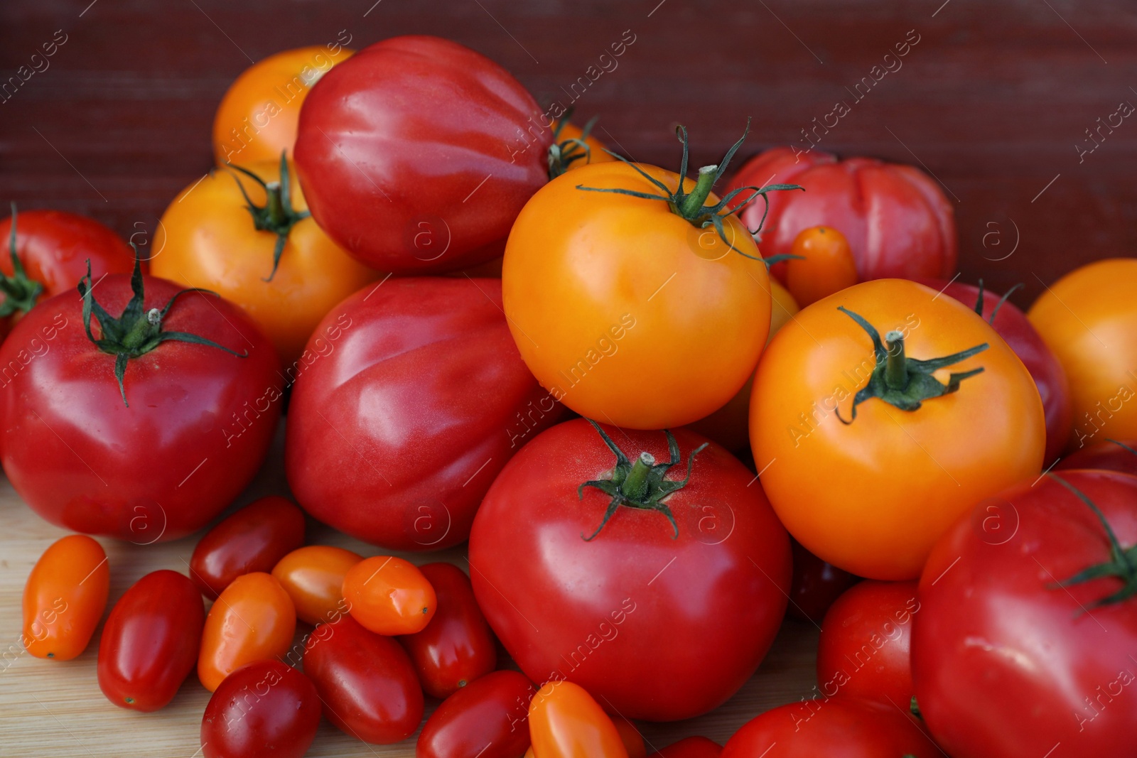 Photo of Different sorts of tomatoes on wooden table