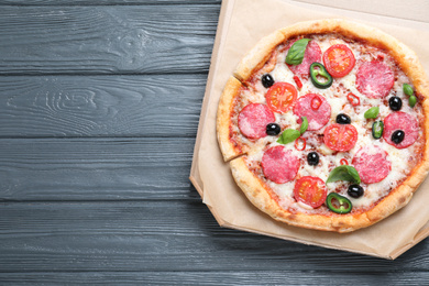 Photo of Delicious pizza Diablo in cardboard box on wooden background, top view. Space for text