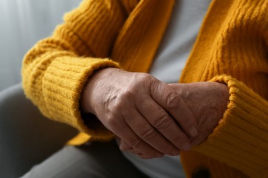 Elderly woman in orange cardigan, closeup view