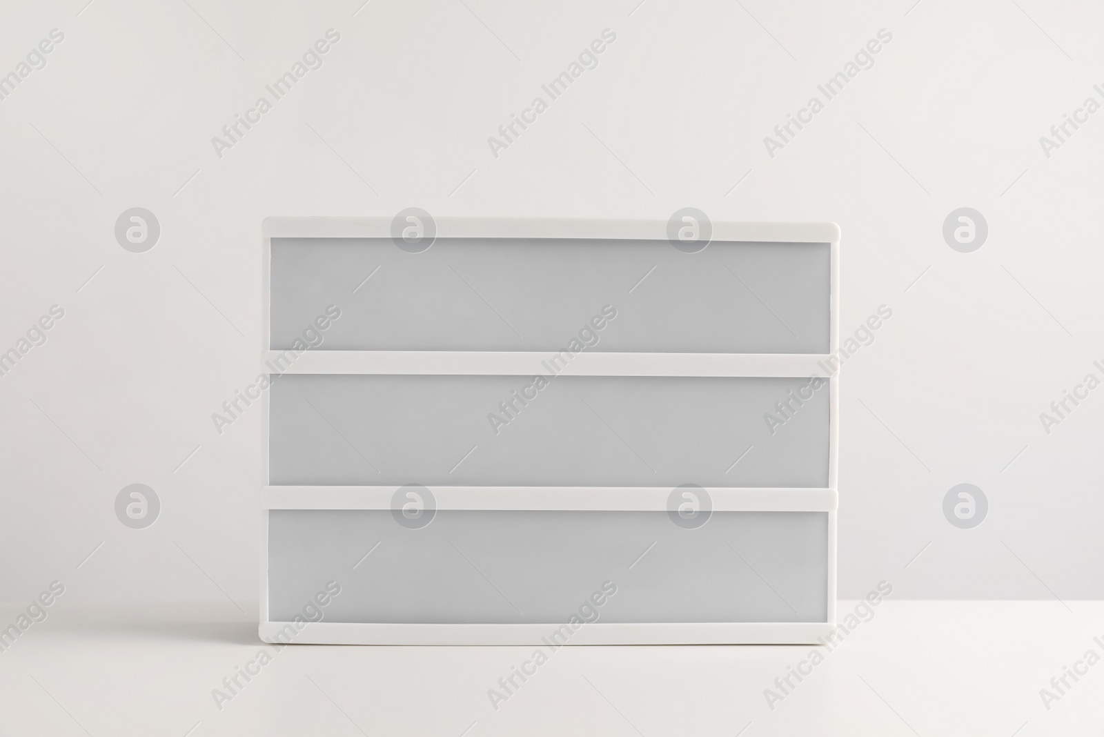 Photo of Blank letter board on white table. Mockup for design