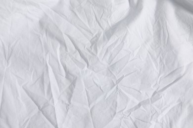 Photo of Crumpled white fabric as background, top view