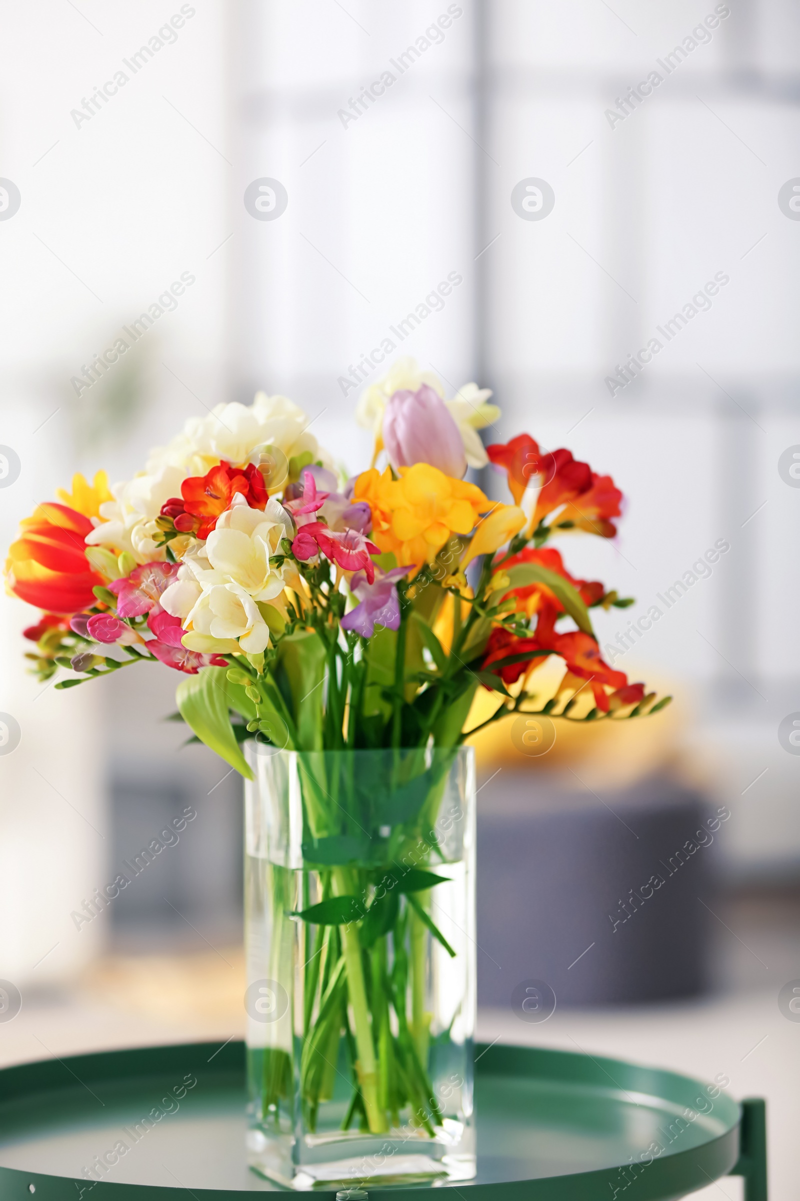 Photo of Beautiful bouquet of freesia flowers indoors