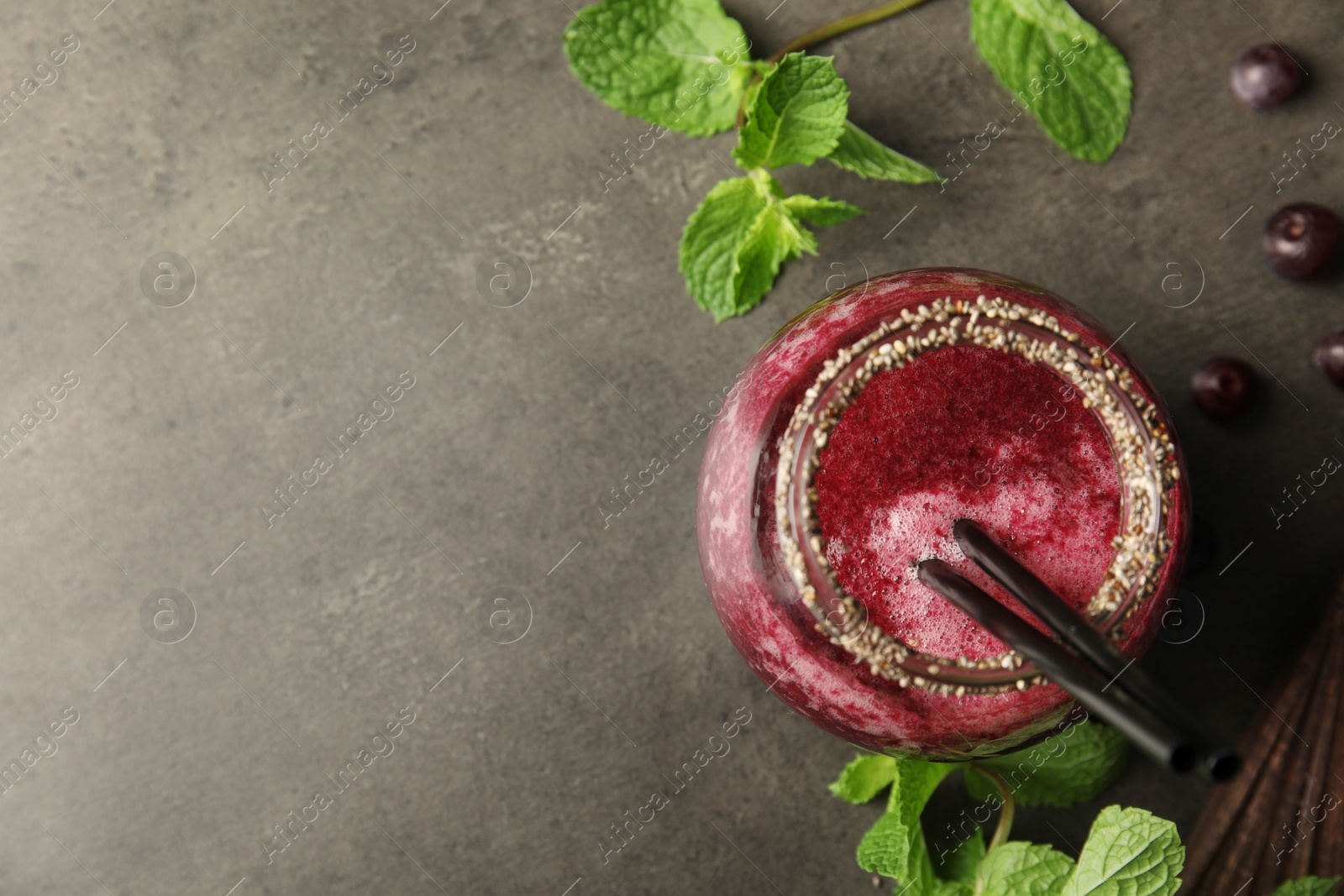 Photo of Flat lay composition with jar of delicious acai juice and fresh mint on dark background