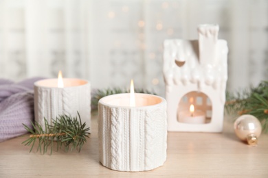 Composition with candle in ornate holder on wooden table. Christmas decoration