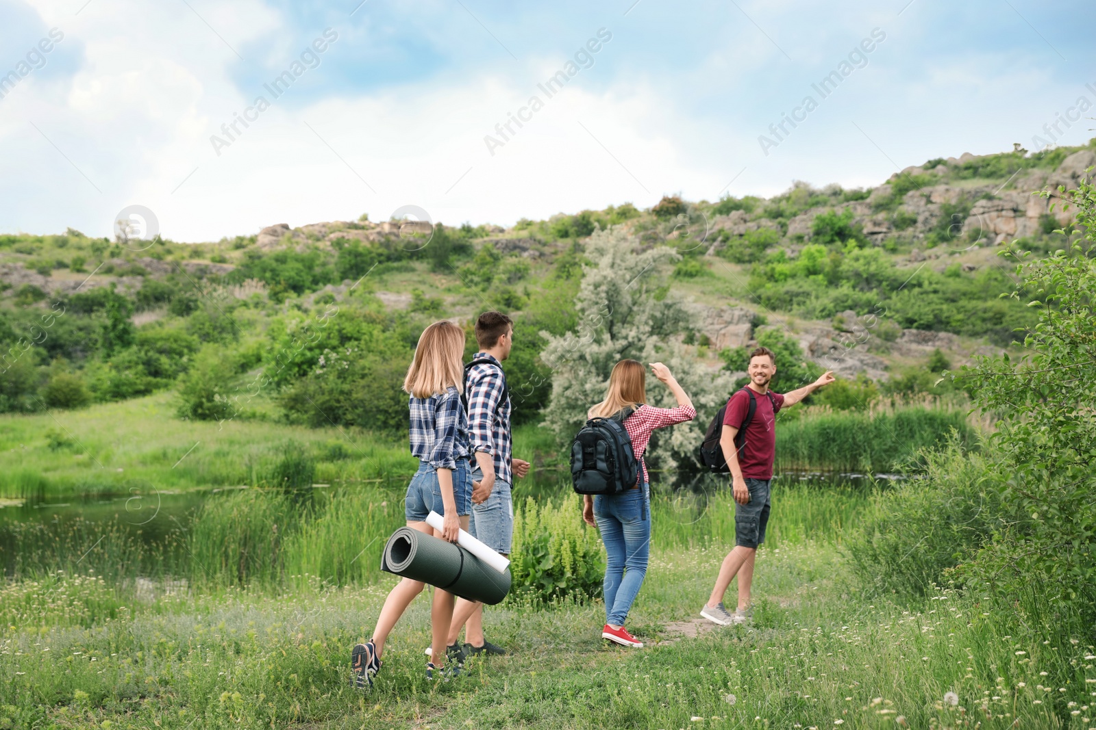 Photo of Group of young people hiking in wilderness. Camping season