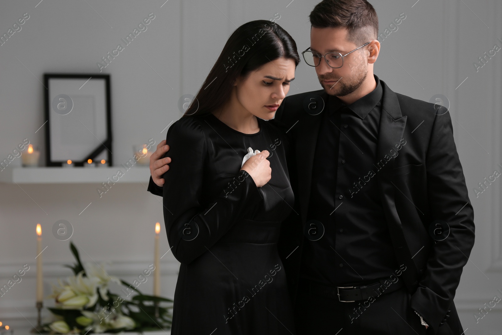 Photo of Sad couple mourning in room. Funeral ceremony