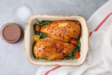 Photo of Baked chicken fillets with vegetables and marinade on grey table, top view