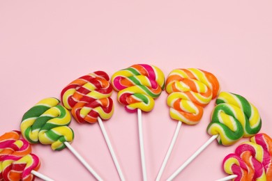 Photo of Sweet lollipops on pink background, flat lay