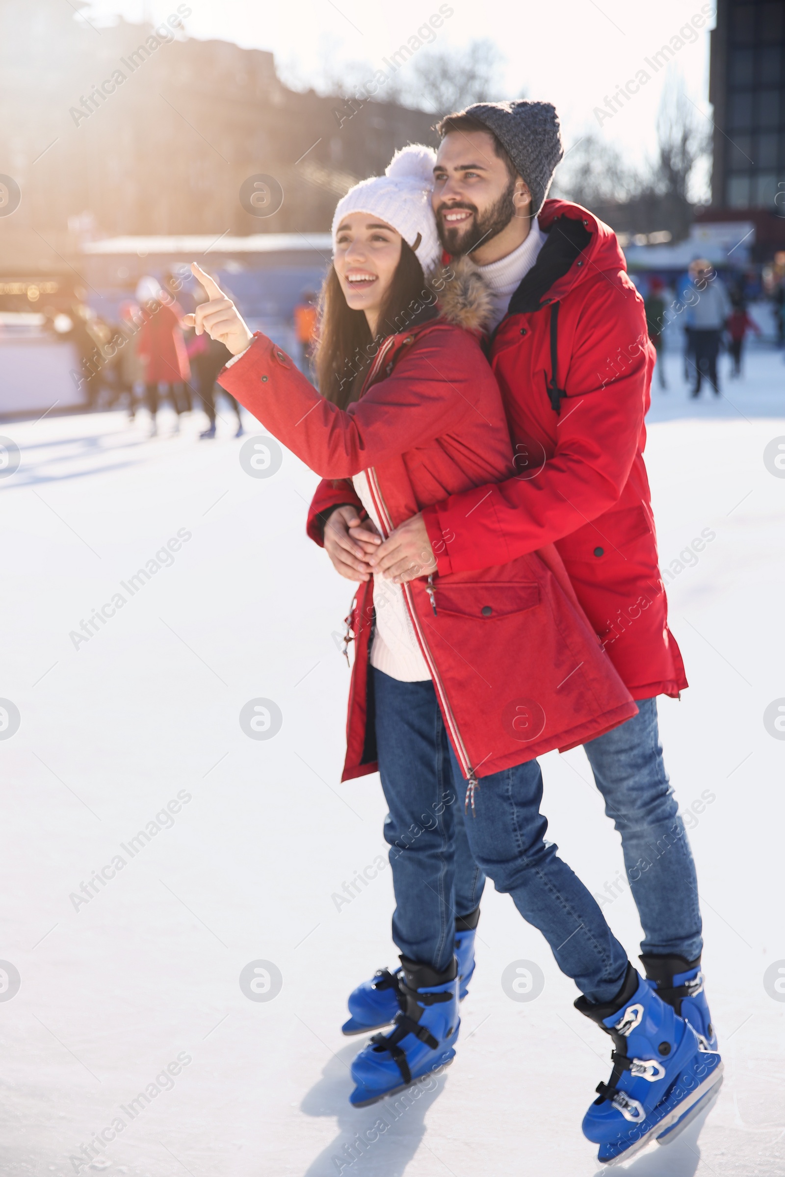 Image of Lovely couple spending time together at outdoor ice skating rink