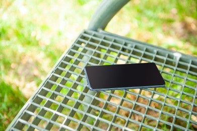 Photo of Smartphone forgotten on metal bench outdoors. Lost and found