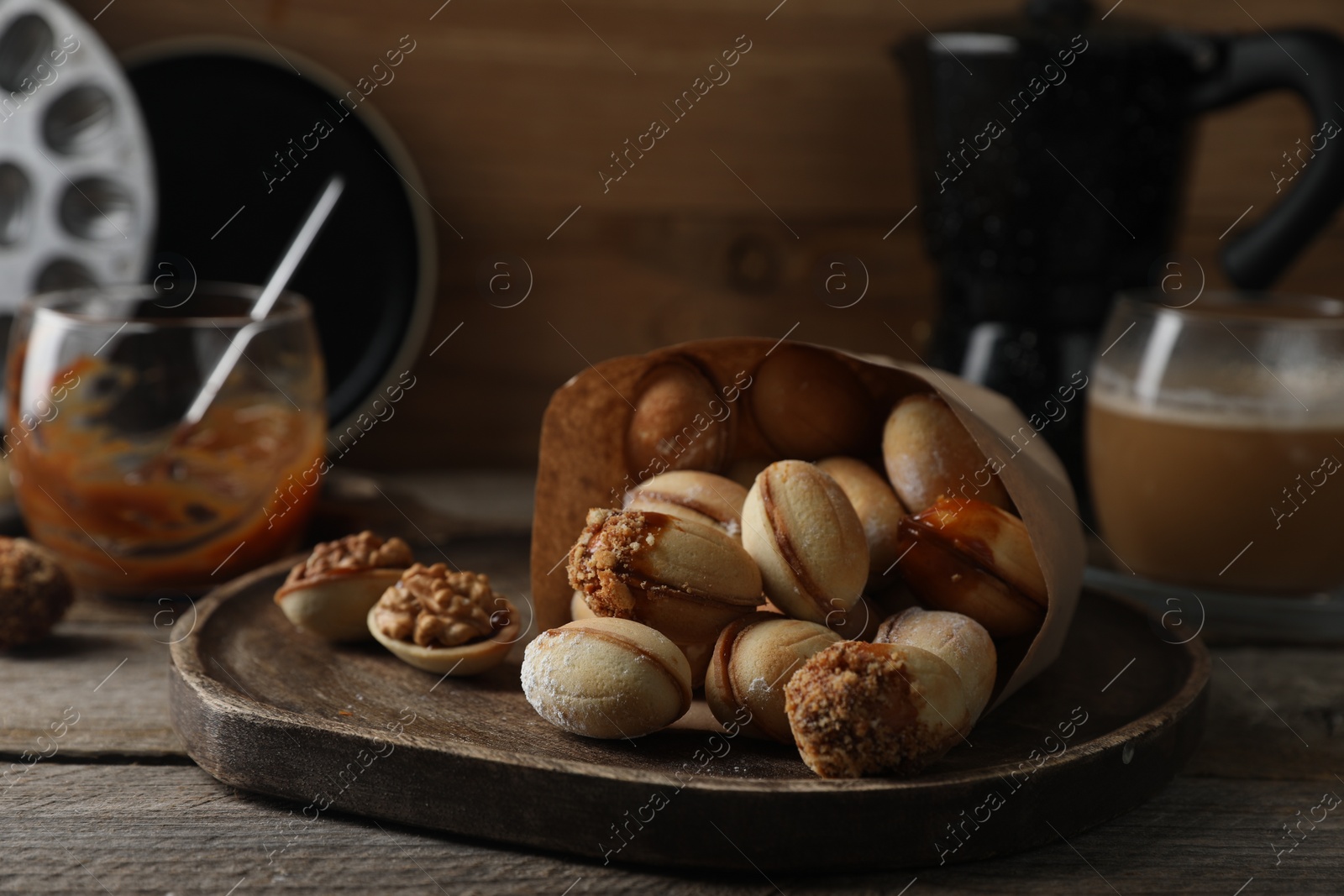 Photo of Freshly baked homemade walnut shaped cookies on wooden table, closeup