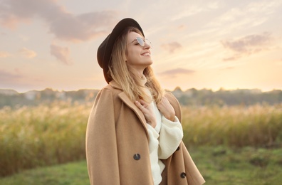 Photo of Beautiful young woman wearing stylish autumn clothes outdoors