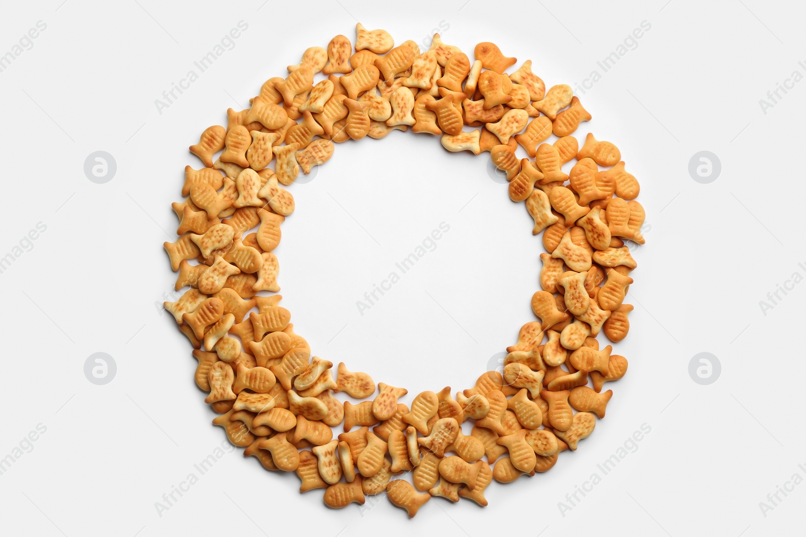 Photo of Frame of delicious goldfish crackers on white background, top view. Space for text