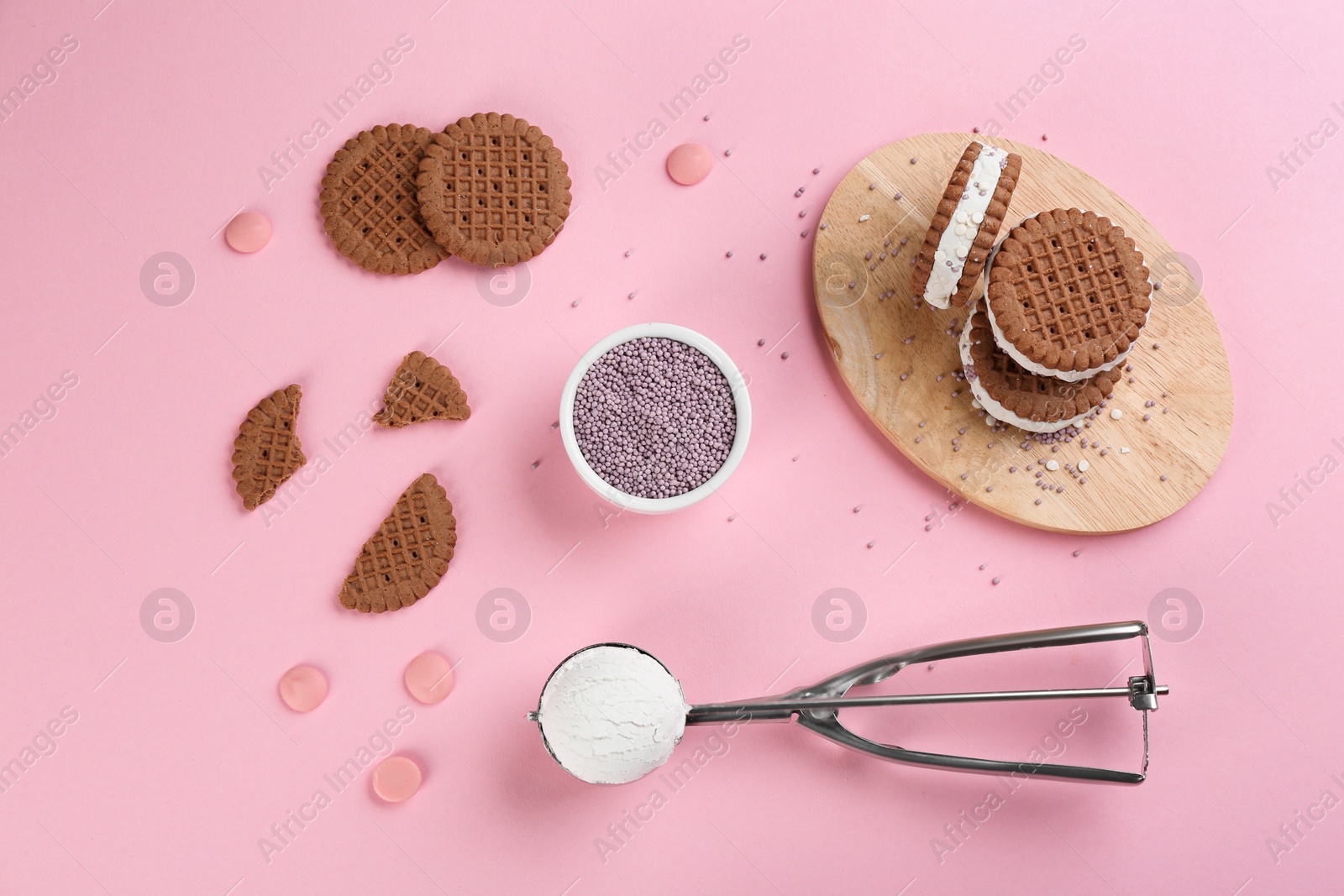 Photo of Sweet delicious ice cream cookie sandwiches on pink background, flat lay