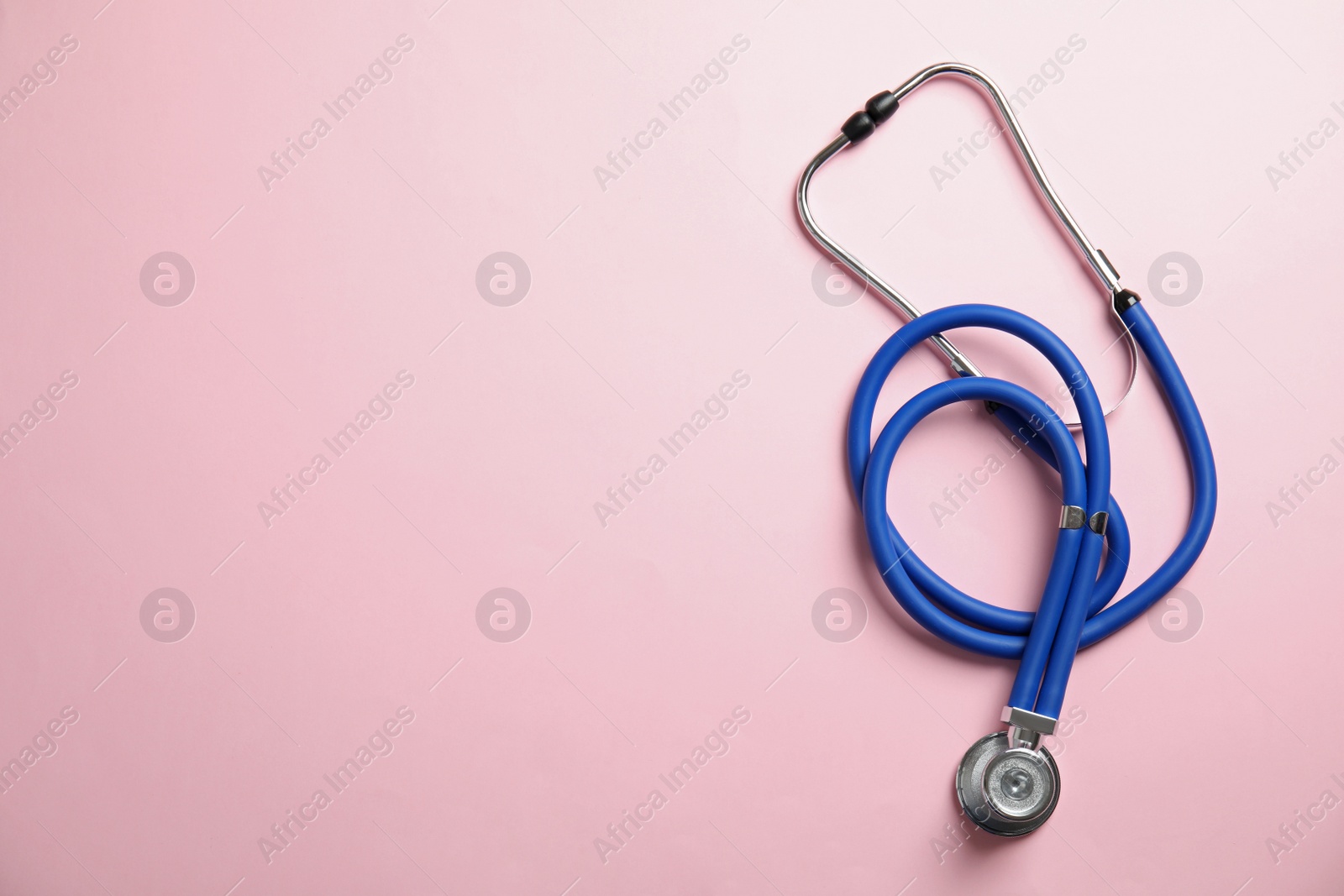 Photo of Stethoscope with space for text on color background, top view. Medical tool