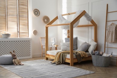 Photo of Stylish child room interior with house bed