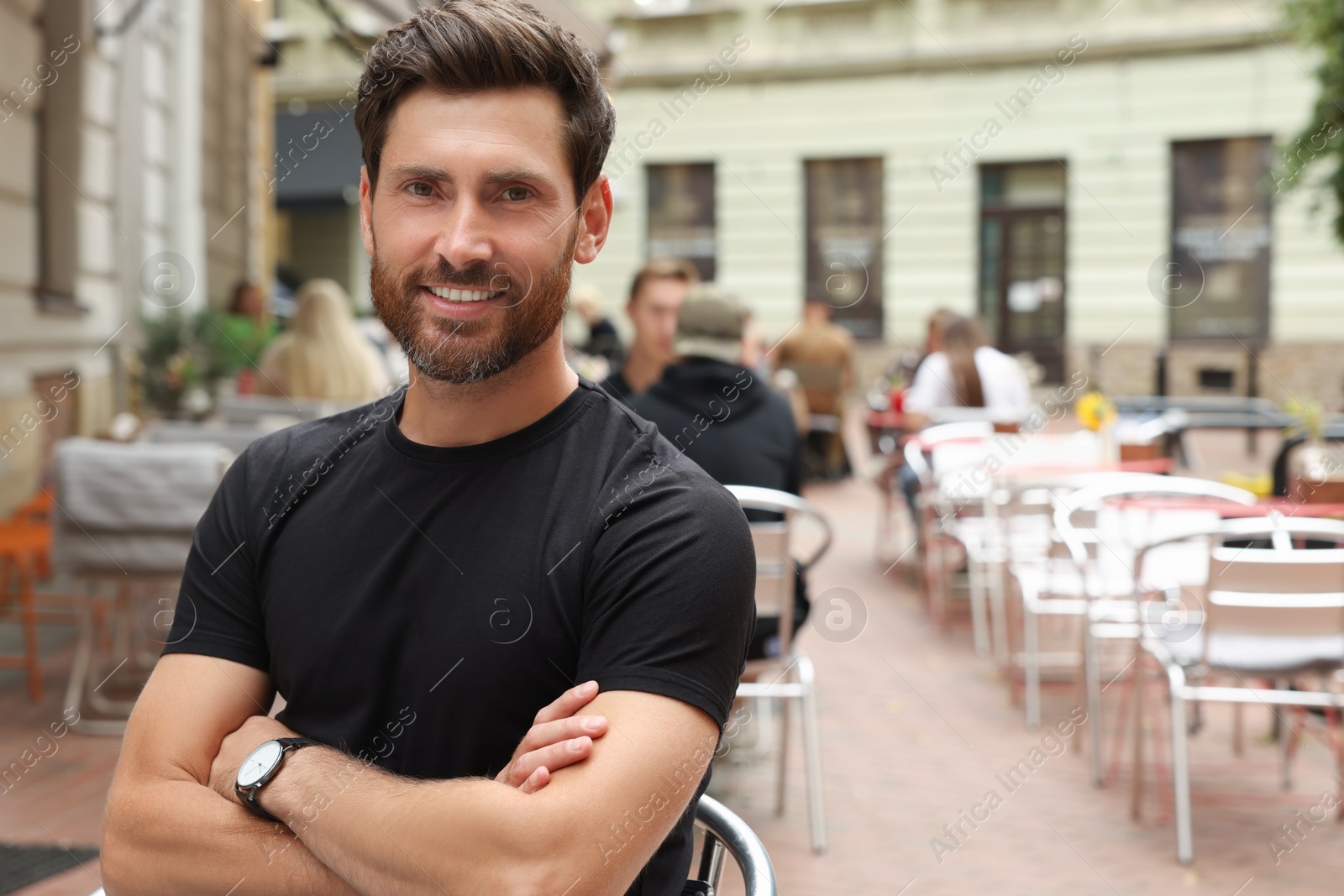 Photo of Portrait of handsome bearded man in outdoor cafe, space for text