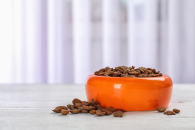 Photo of Bowl with food for cat or dog on floor. Pet care