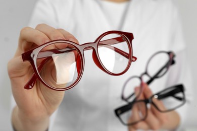 Photo of Woman with different glasses on light background, closeup
